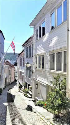 a white house with an american flag on a street at Beautiful apartment in the heart of Bergen in Bergen