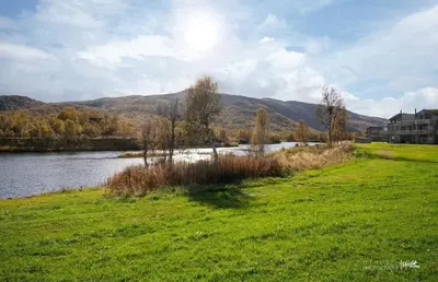 a grassy field next to a body of water at New! Stay close to Hardangervidda & Vøringsfossen in Eidfjord