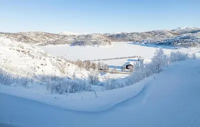 a snow covered field with a building in the background at 2 Bedroom Lovely Apartment In Rjukan in Rjukan