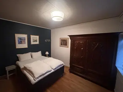 a bedroom with a bed and a wooden cabinet at City apartment in Bergen in Bergen