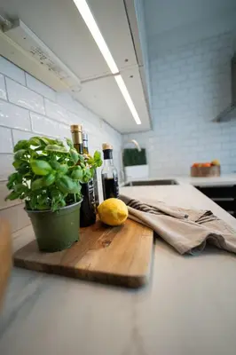 a cutting board with bottles of wine and a plant at Ultra central flat with balcony in Bergen
