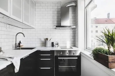 a kitchen with black cabinets and a sink and a window at Ultra central flat with balcony in Bergen