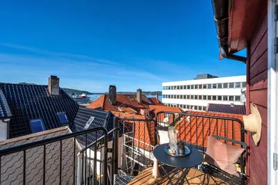 a balcony with a table and a view of the city at Toppleilighet på Sandviken med balkong in Bergen