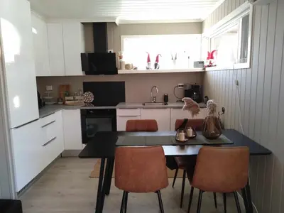a small kitchen with a table and chairs in it at Holiday home near all facilities in Grinde, Aksdal in Tysvær
