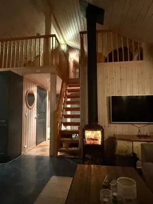a living room with a fireplace and a staircase at Cozy ski in&out cabin Hemsedal in Hemsedal