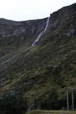 a mountain with a waterfall on the side of it at Alnes Gård in Ålesund