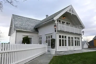 a white house with a white fence at Alnes Gård in Ålesund