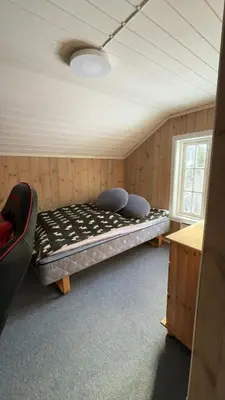 a room with a bed in the corner of a room at Quiet detached house in Haukeli, modern and homey in Haukeligrend