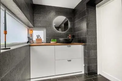 a bathroom with a sink and a mirror at House 2 rooms in Trondheim