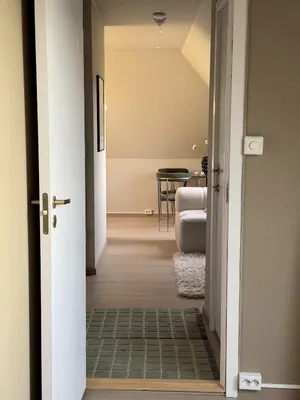 a hallway leading to a living room with a table at Cozy loft apartment in the heart of Bergen in Bergen