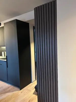 a black partition in a room with a kitchen at Great apartment in the center of Ålesund in Ålesund