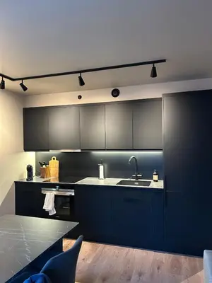 a kitchen with black cabinets and a sink at Great apartment in the center of Ålesund in Ålesund