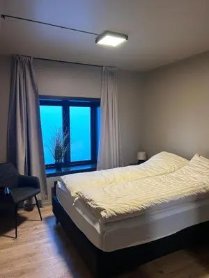 a bedroom with a bed and a large window at Great apartment in the center of Ålesund in Ålesund