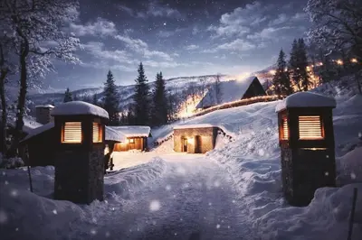 a snow covered house with lights in the snow at Skogstad Lodge, Hemsedal in Hemsedal