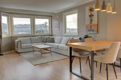 a living room with a couch and a table at Central apartment with parking in unique surroundings in Bergen