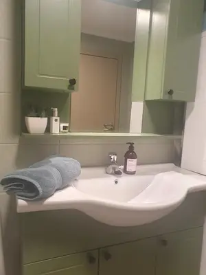 a bathroom sink with a towel and a mirror at Central apartment with parking in unique surroundings in Bergen