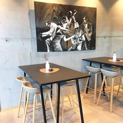 two tables in a restaurant with a painting on the wall at Hjorten Hotell Hitra in Fillan
