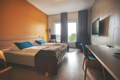 a hotel room with a bed and a desk and a window at Hjorten Hotell Hitra in Fillan
