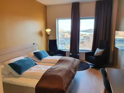 a hotel room with two beds and a large window at Hjorten Hotell Hitra in Fillan