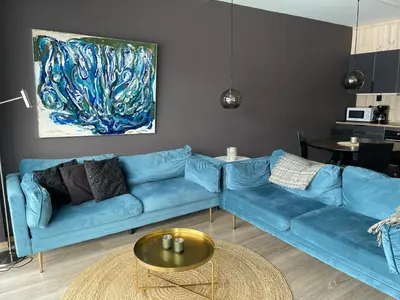a living room with a blue couch and a table at Ski-in & out Totten Lodge apartment two bedrooms in Hemsedal