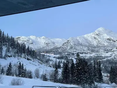 a view of a snow covered mountain from a window at Ski-in & out Totten Lodge apartment two bedrooms in Hemsedal
