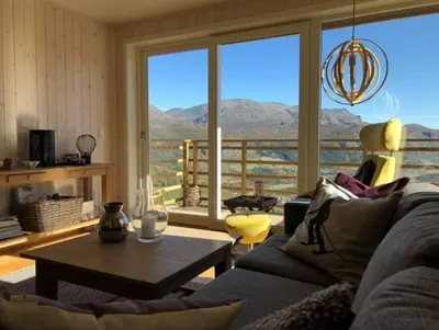 a living room with a couch and a large window at Skarsnuten Panorama 61, Hemsedal in Hemsedal