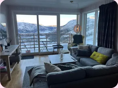 a living room with a couch and a large window at Skarsnuten Panorama 61, Hemsedal in Hemsedal