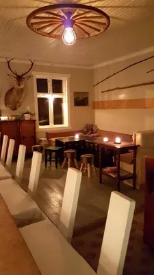 a dining room with a table and chairs and a chandelier at Rødseter Gjestegård in Fjarland