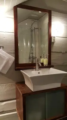 a bathroom with a white sink and a mirror at Rødseter Gjestegård in Fjarland