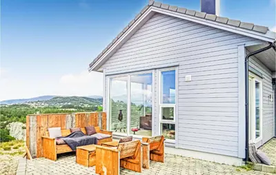 a house with a patio with a couch and chairs at Beautiful Home In Fitjar in Fitjar