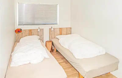 two beds in a room with a window at Beautiful Home In Fitjar in Fitjar