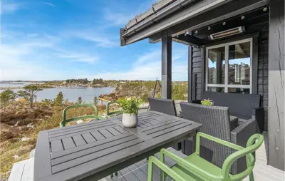 a patio with a table and chairs and a view of the water at 4 Bedroom Nice Home In Tustna in Leira