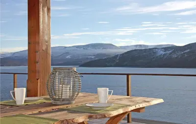 a table on a deck with a view of the mountains at Holiday Home Hol With A Fireplace 02 in Hovet