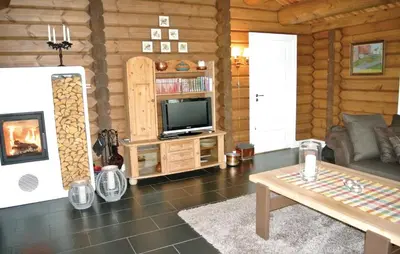 a living room with a television in a wooden cabin at Holiday Home Hol With A Fireplace 02 in Hovet
