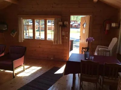 a dining room with a table and chairs and a window at Furuly Camping in Nordberg