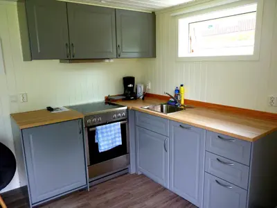 a kitchen with green cabinets and a sink and a stove at Setnes Feriesenter in Veblungsnes