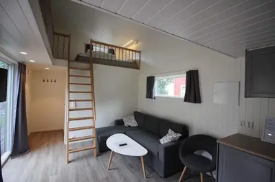 a living room with a couch and a staircase in a tiny house at Setnes Feriesenter in Veblungsnes