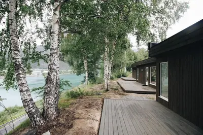 a house with a wooden walkway next to a river at Setnes Feriesenter in Veblungsnes