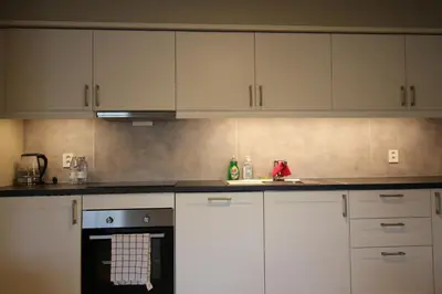 a kitchen with white cabinets and a sink at Setnes Feriesenter in Veblungsnes