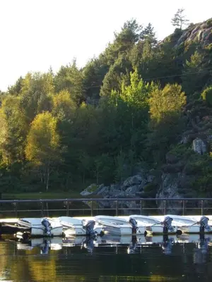 a group of boats sitting on the water at Hagland Lille Haugesund 8x Ferienhaus incl Motorboot in Hagland