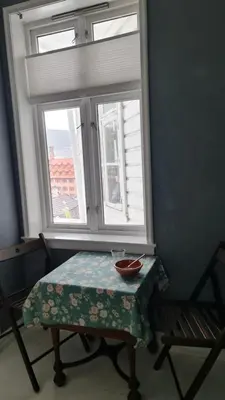 a table and a chair in front of a window at Amunds Apartment in Bergen