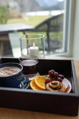 a tray with a plate of food and a candle at Valldal Fjordhotell - by Classic Norway Hotels in Valldal