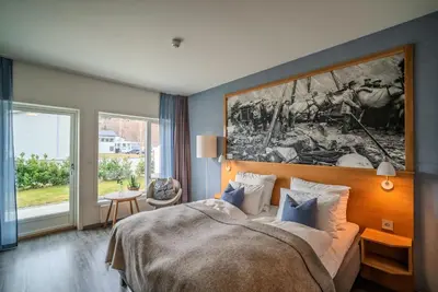 a bedroom with a bed and a large painting on the wall at Valldal Fjordhotell - by Classic Norway Hotels in Valldal