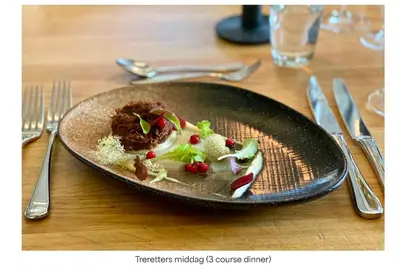 a black plate of food on a wooden table at Turtagrø Hotel in Fortun