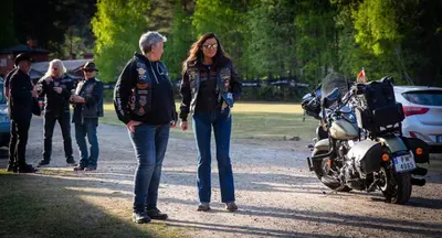 two women are standing next to a motorcycle at Frya Leir in Frya
