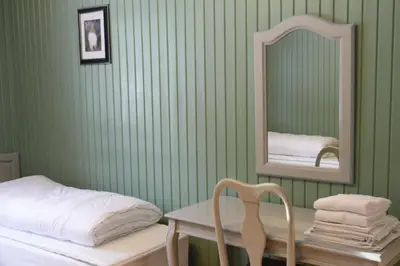 a green room with a bed and a mirror at Frya Leir in Frya