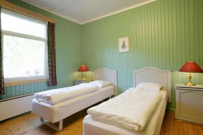 two beds in a room with green walls and a window at Frya Leir in Frya