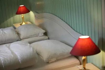 a bedroom with two white pillows and a red lamp at Frya Leir in Frya