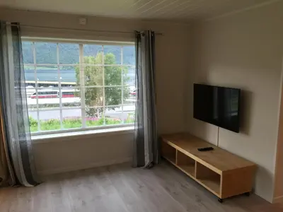 a living room with a large window and a flat screen tv at Villa Haudalan Åndalsnes in Åndalsnes