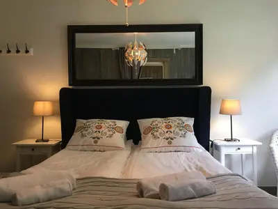 a bedroom with a bed with a mirror and two lamps at Kvamseter Lodge in Kvamseter